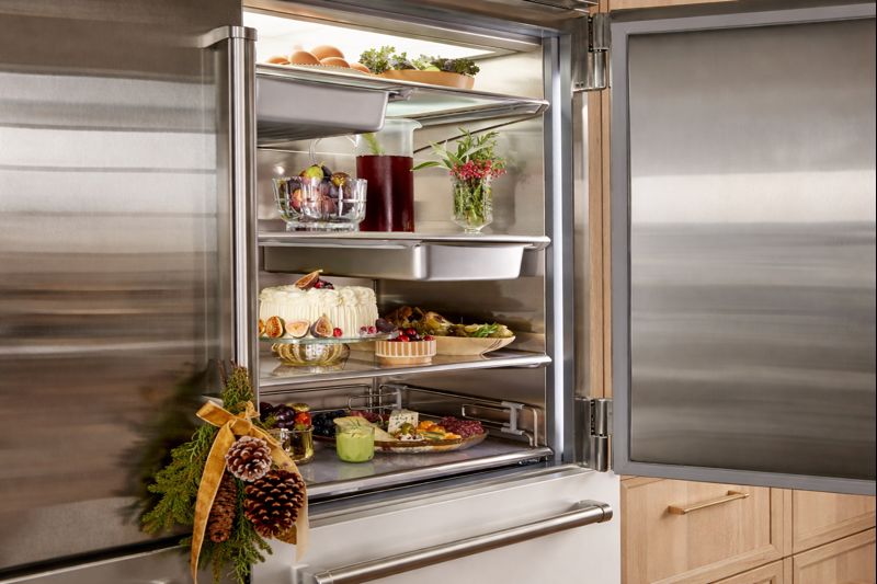 Open Sub-Zero refrigerator with stocked shelves and holiday decor, when to call a professional repair